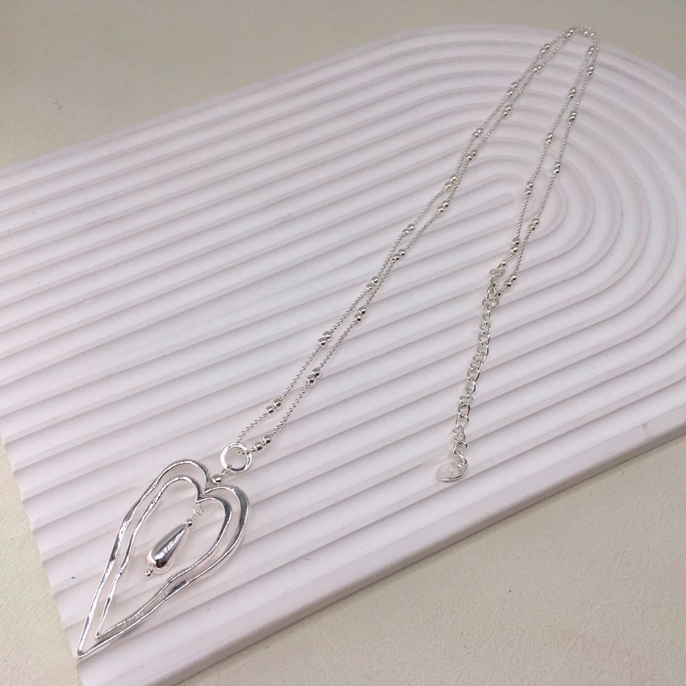 Double Heart Necklace on a display stand.
