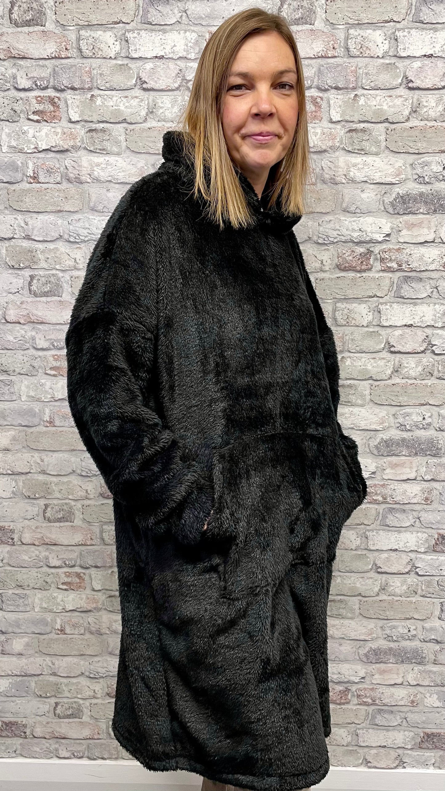 Unisex Blanket Hoodie in black, incredibly soft with hood and front pocket.
