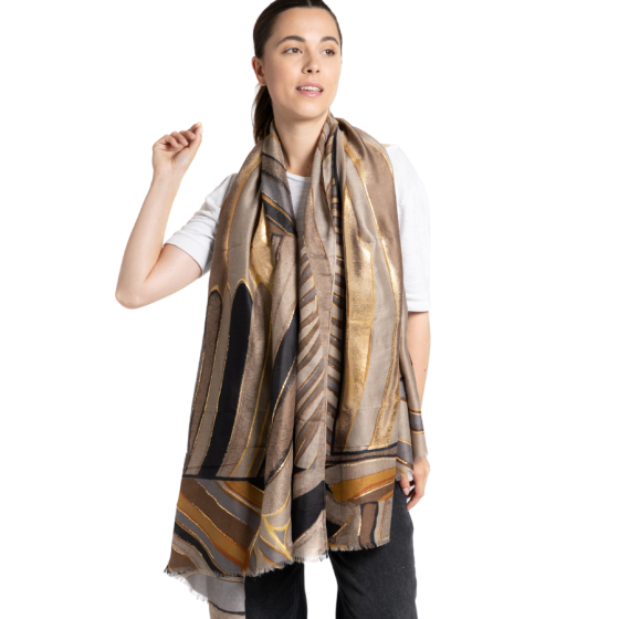 Gold abstract scarf with a stylish design in gold, grey, and blue, worn by a woman.