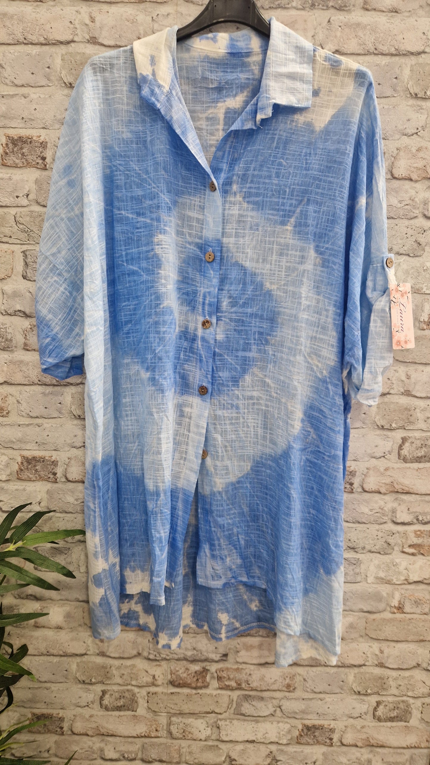 Tie Dye Cotton Shirt hanging on a brick wall background.