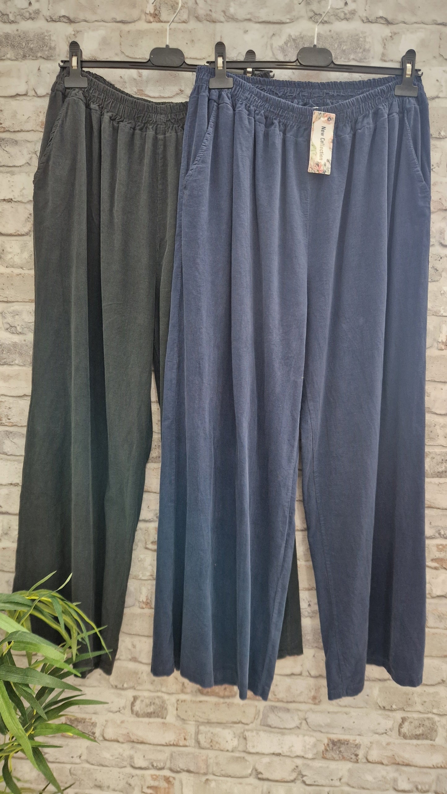 Cord wide leg trousers in black and navy, featuring a relaxed cut with side pockets, made from 100% cotton.