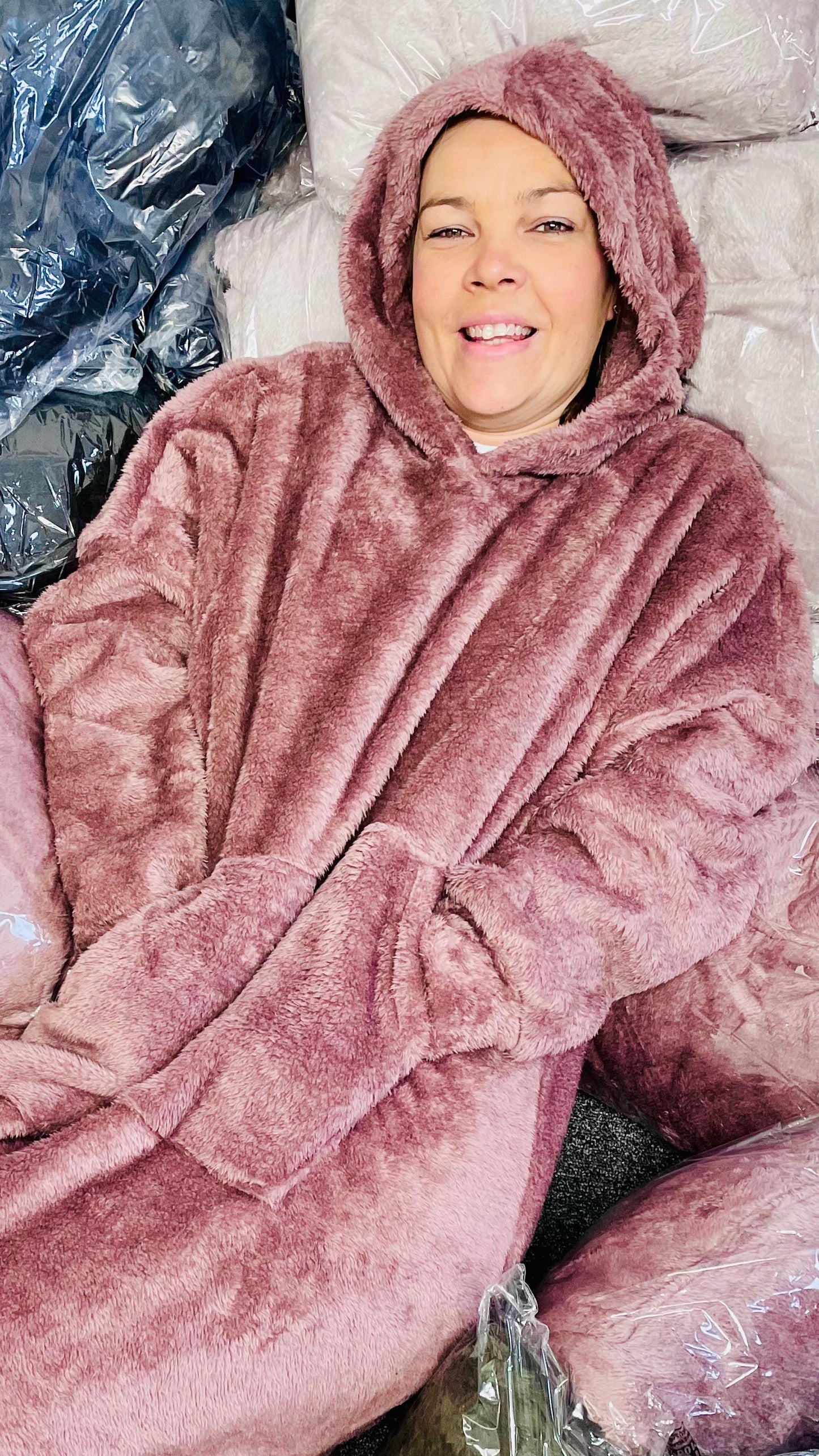 Unisex blanket hoodie in soft pink with hood and front pocket.