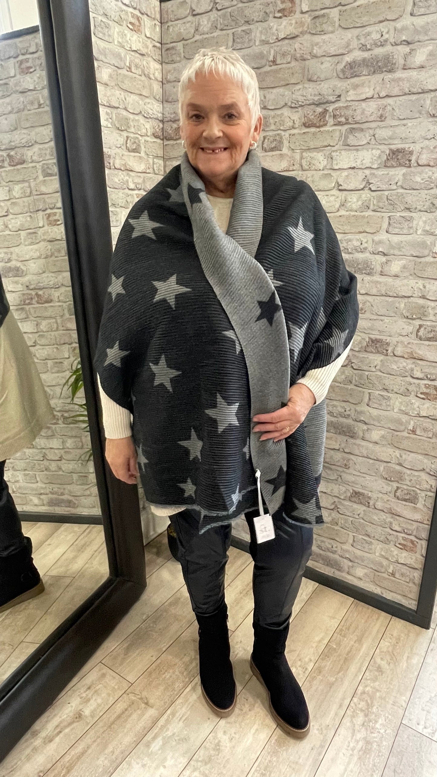 Pleated Star Scarf with textured folds and reversible colors, 100% polyester.