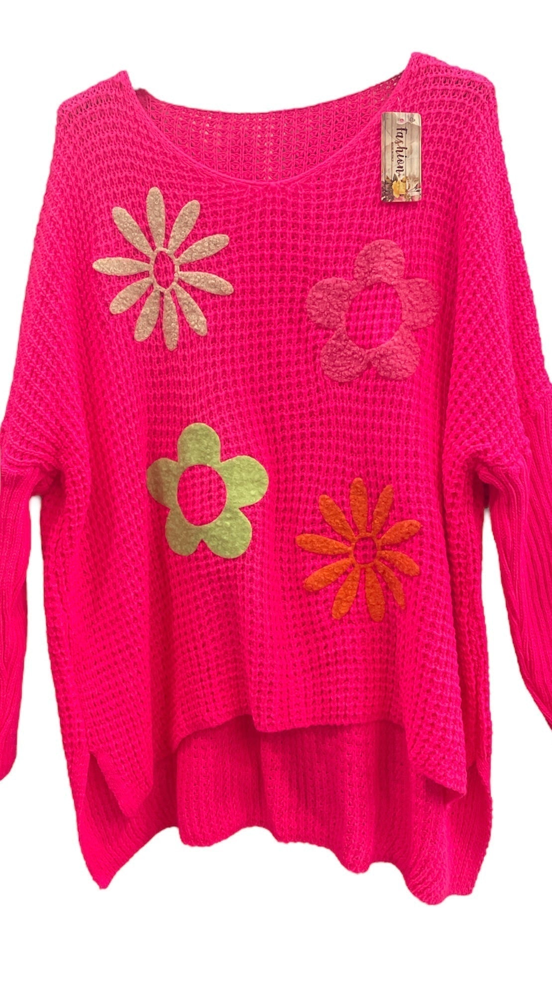 Bright pink side slit floral jumper made from 100% acrylic with colorful embroidered flowers.
