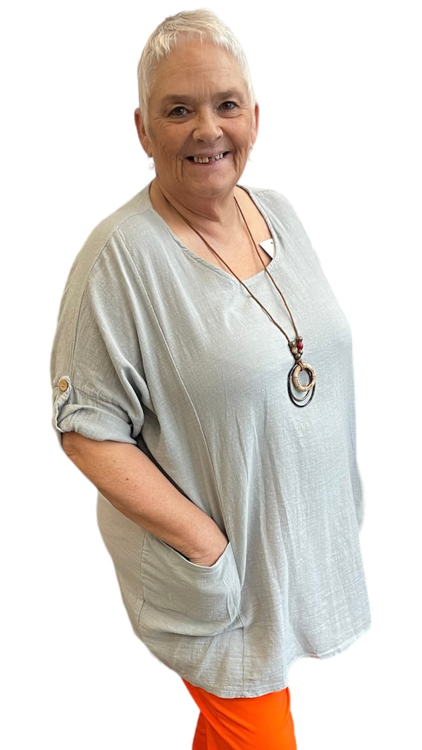 Plain Necklace Pocket Top in light fabric with included necklace and two front pockets, worn by model.