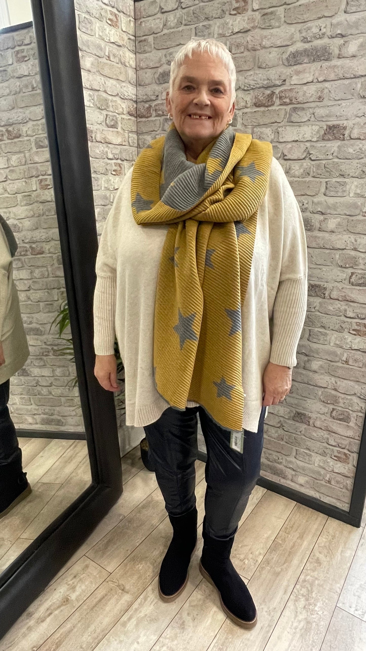 Pleated Star Scarf with textured folds and reversible colors, 100% polyester.
