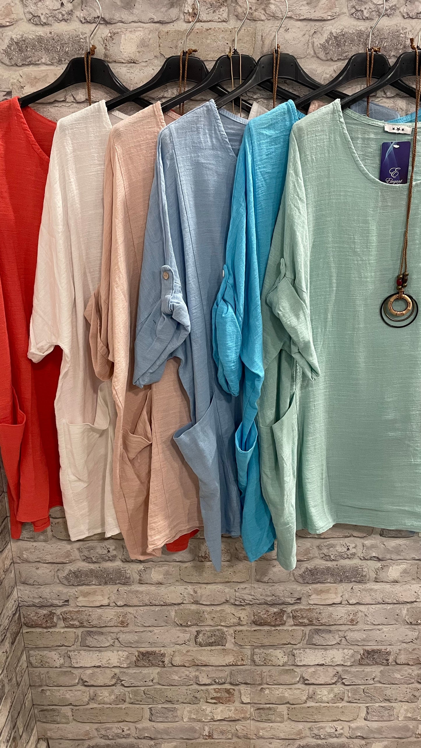 Plain Necklace Pocket Top in various colors with necklace included, made in Italy, displayed on hangers.