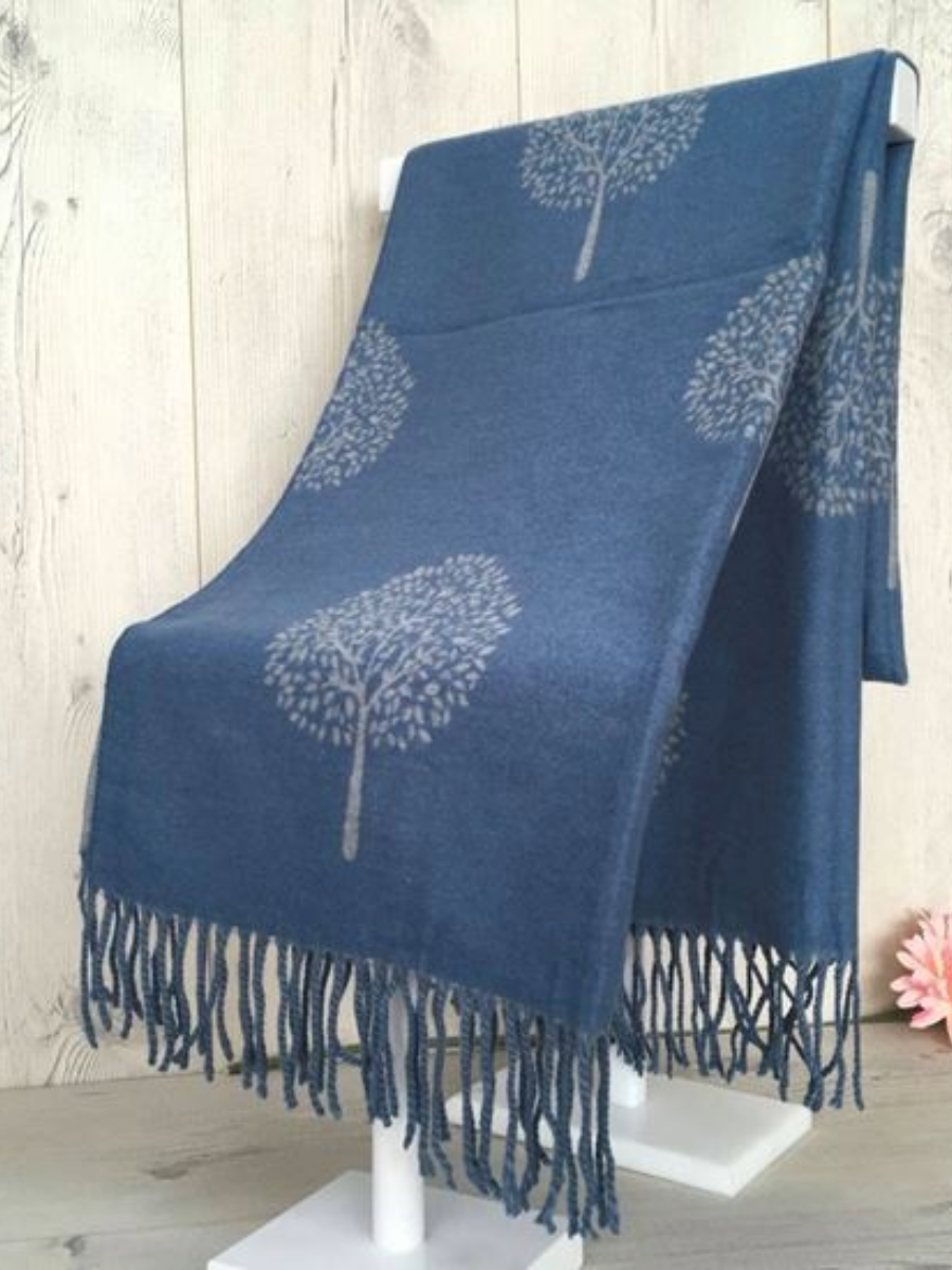 Cashmere Winter Scarf with a tree design and tassels on a display stand. Blue