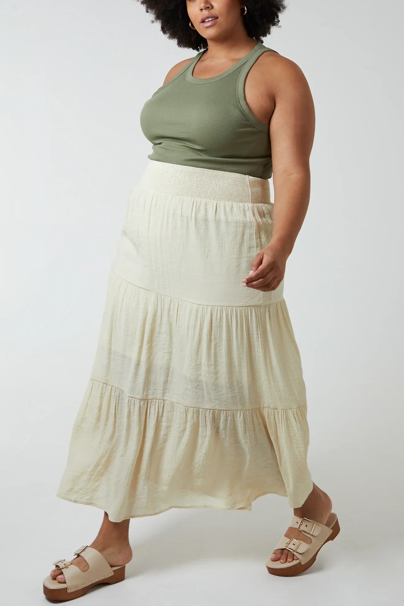 Shirred Waist Maxi Skirt in cream color, worn by a model, made of 64% viscose and 36% polyester.