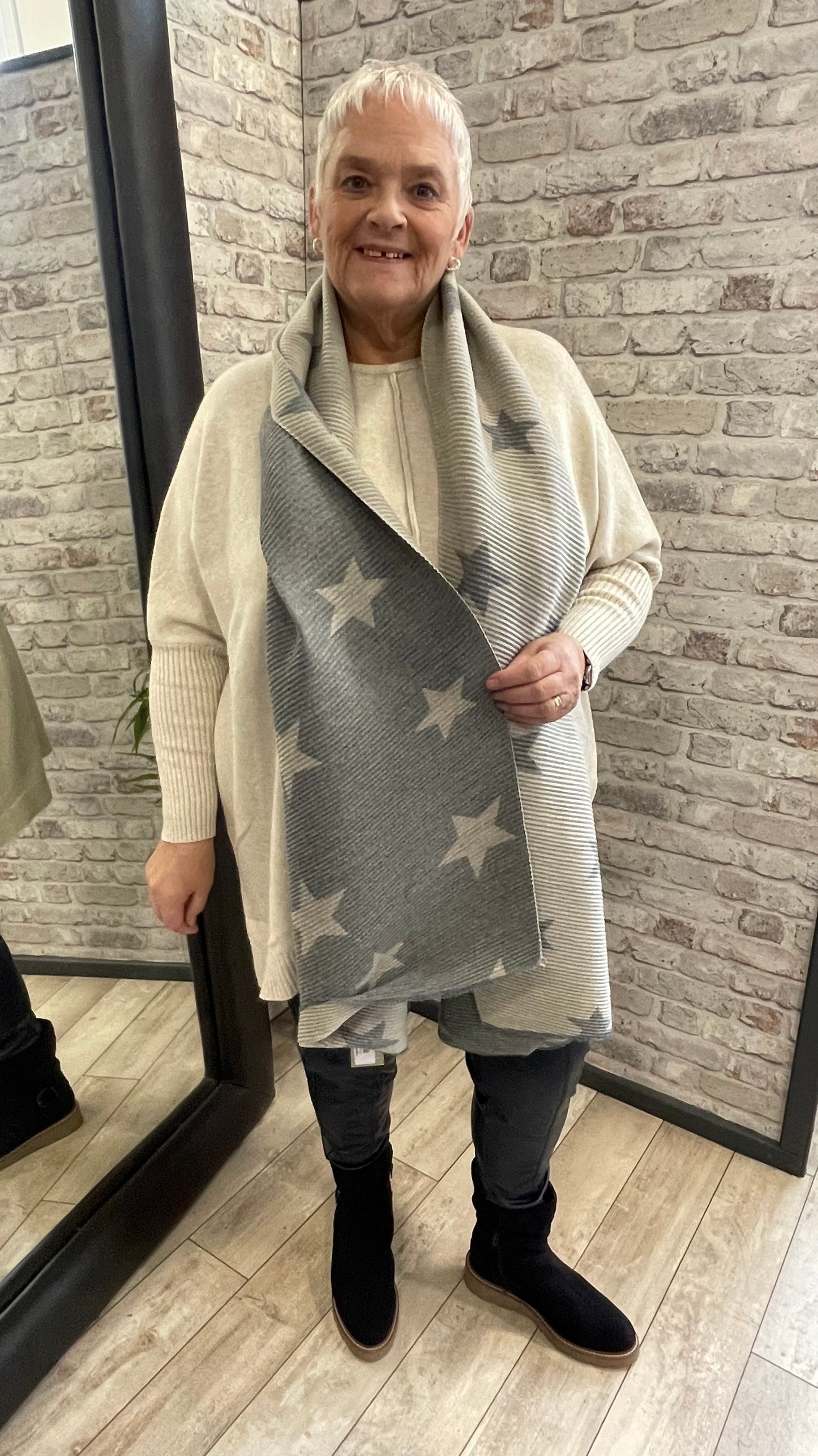 Pleated Star Scarf with textured folds and reversible colors, 100% polyester.