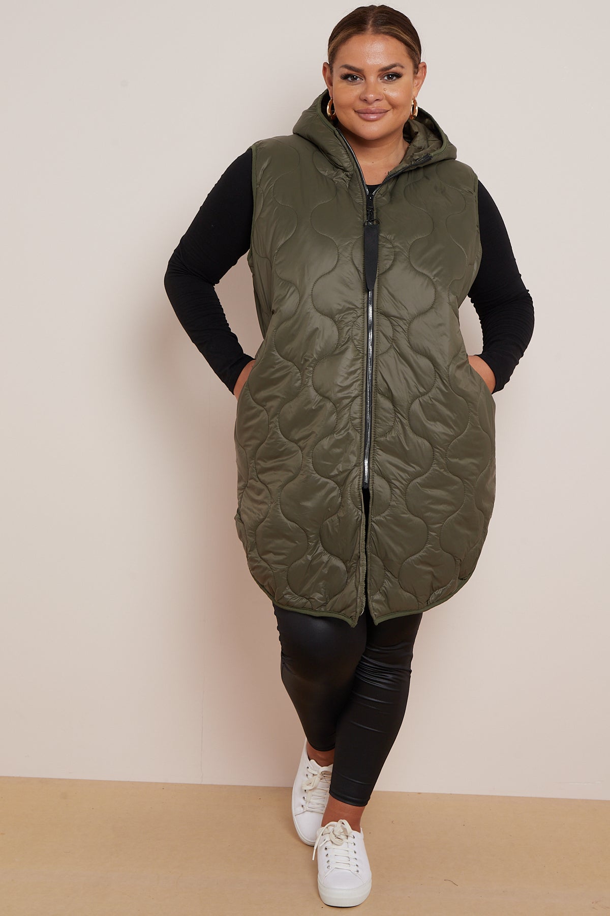 Lightweight padded gilet in olive green, featuring a hood and side pockets.