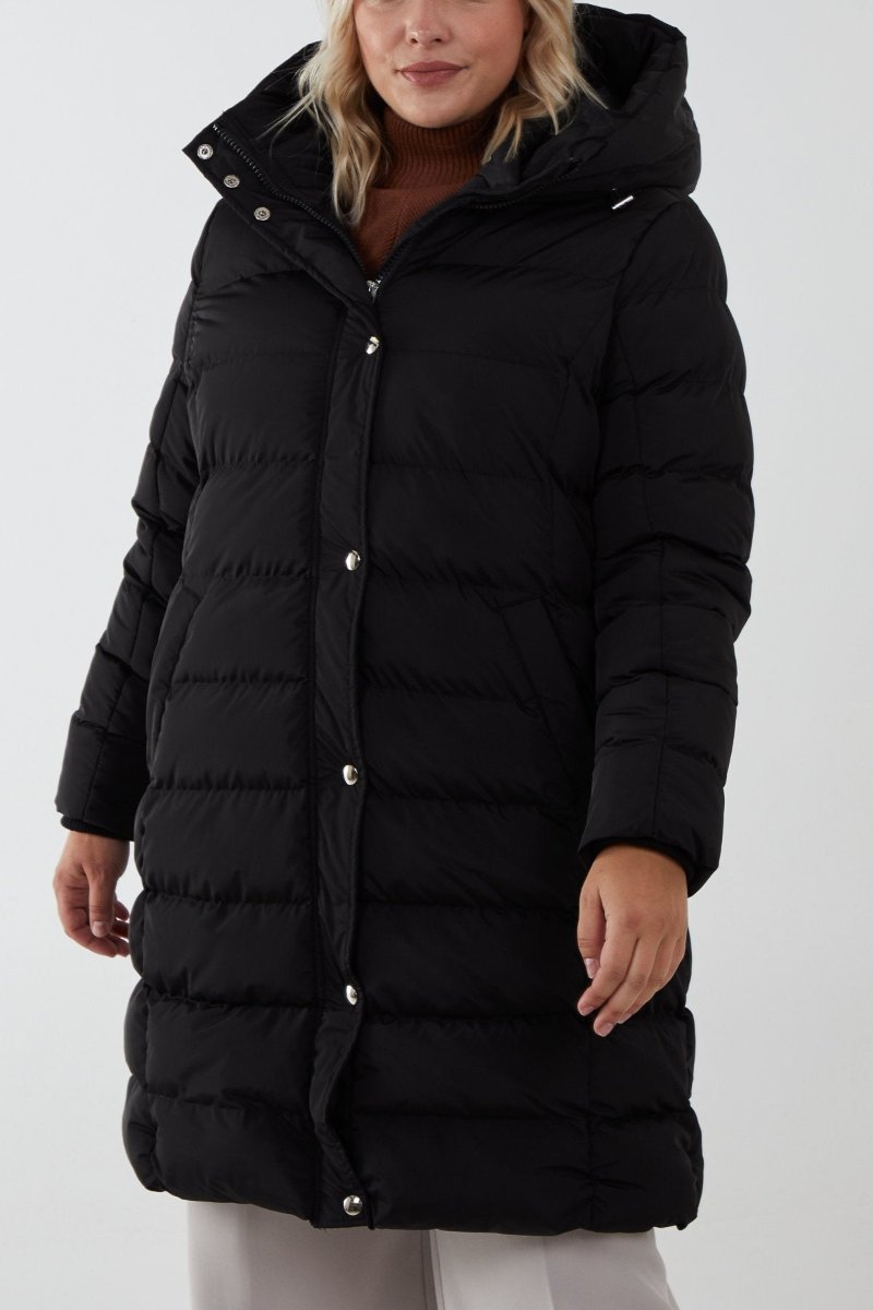 Longline black puffer jacket with hood, designed for warmth in high winds and freezing conditions.
