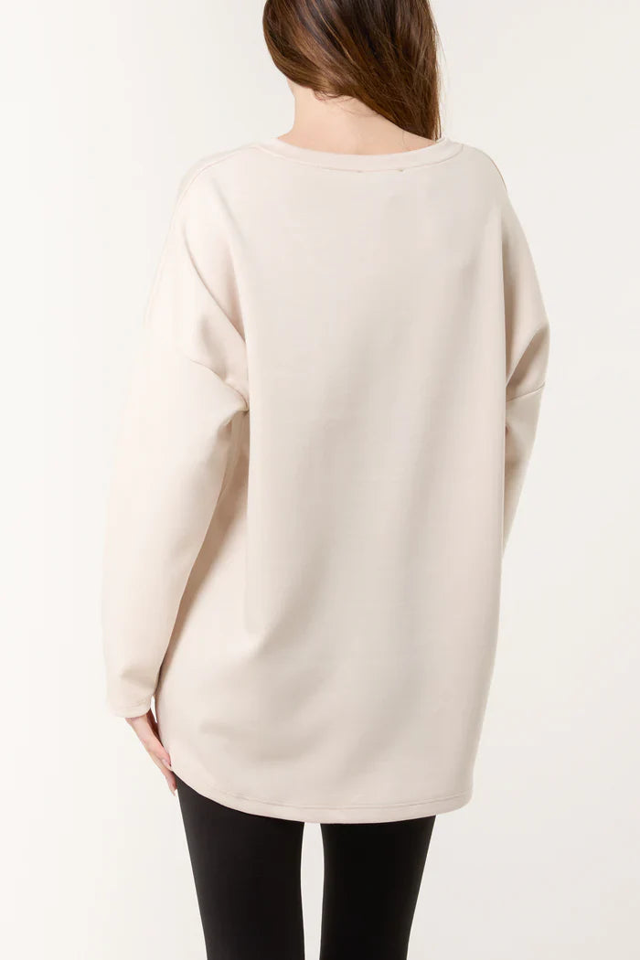 New York V Neck Sweater in beige, showcasing a relaxed fit with long sleeves, perfect for layering.