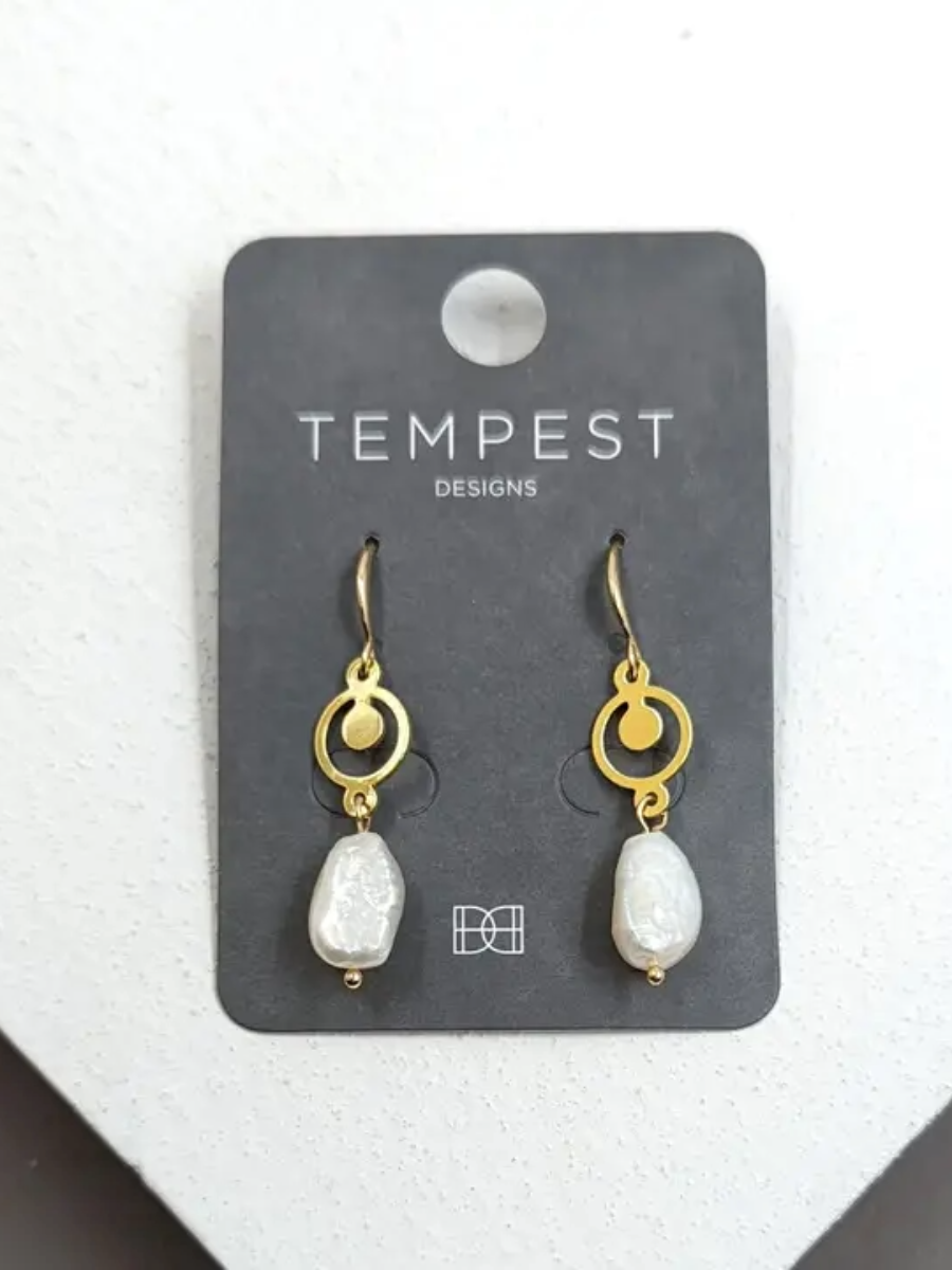 Gold circle and pearl earrings on display card.