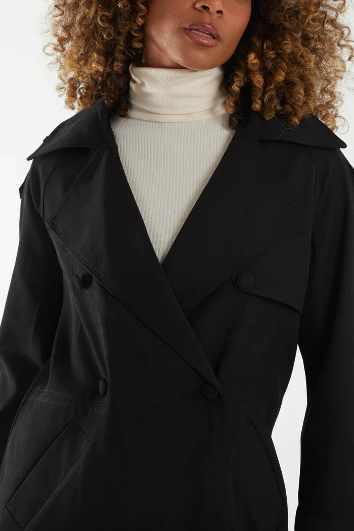 Double breasted trench coat in black, 100% polyester, worn by a model.