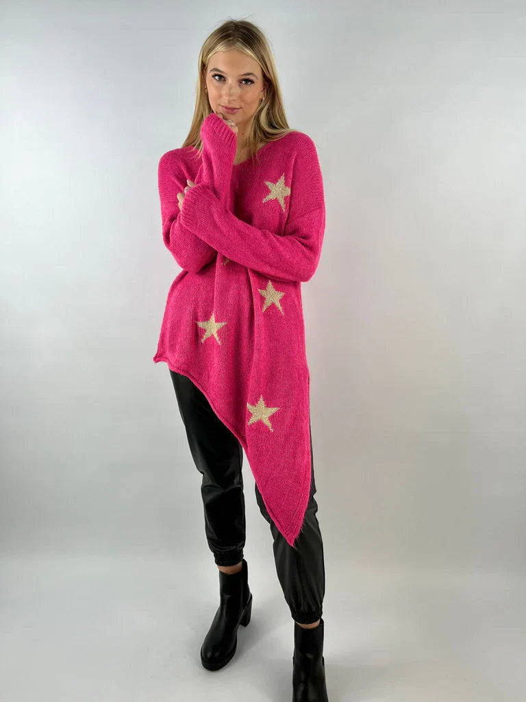 Woman wearing pink asymmetric star jumper with star patterns and asymmetric hem.