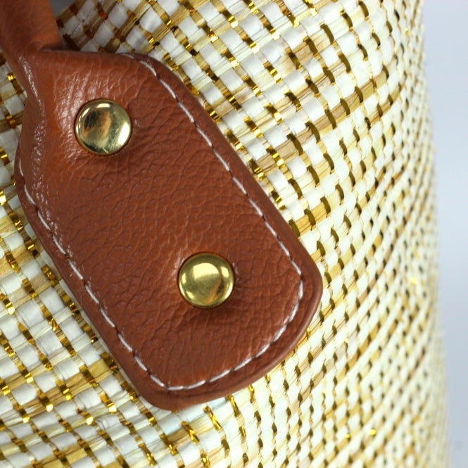 Close-up of Byron Beach Bag's brown faux leather strap on metallic woven paper straw material.
