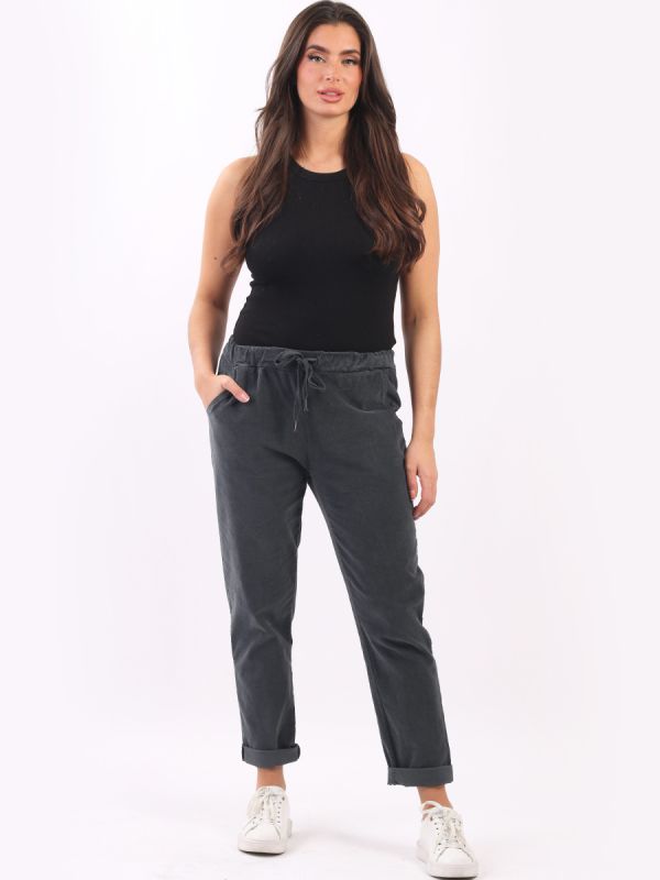 Woman wearing cotton corduroy trousers with elastic waistband and drawstring belt.