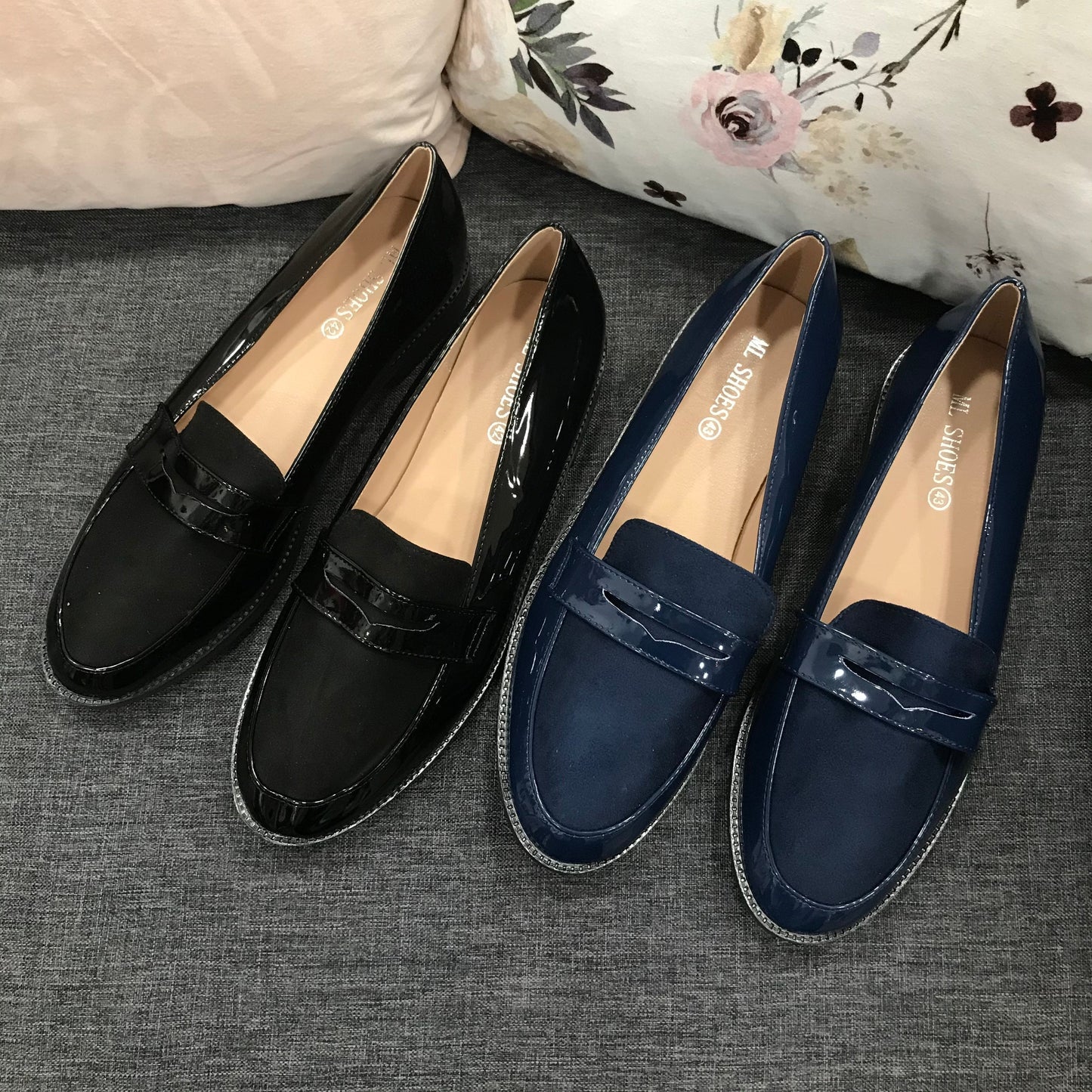Larger Size Patent Loafer in black and navy on a couch.