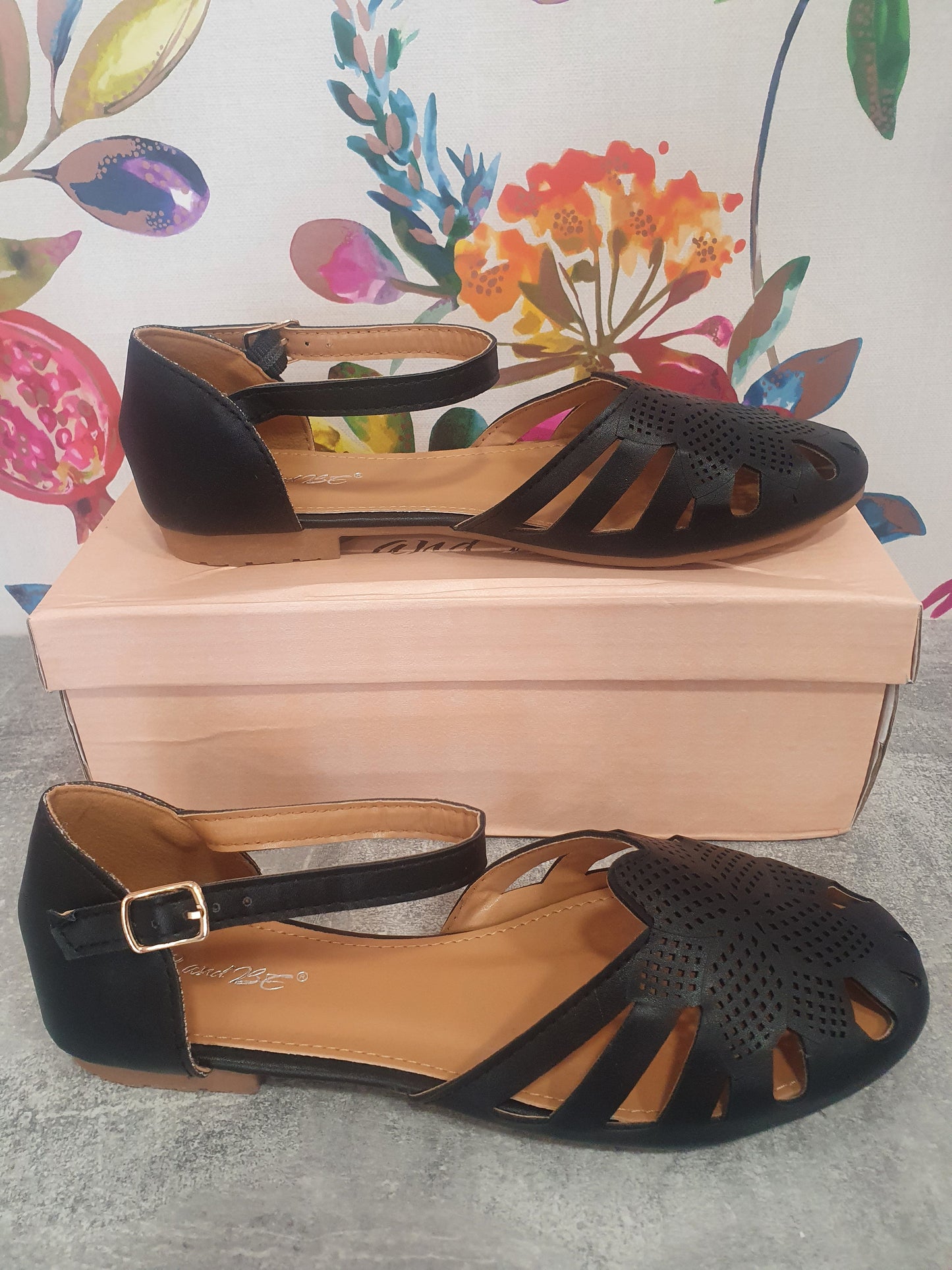 Filigree Ankle Strap Shoes in black with perforated design on display.