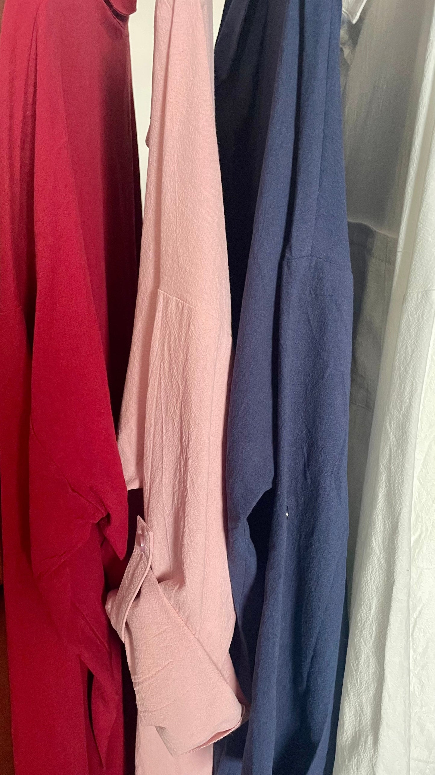 Multi-colored plain thick longline shirts hanging in a row.