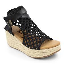 Blowfish Lorrah Black wedge sandal with braided detailing, cutout upper, and buckle accents.
