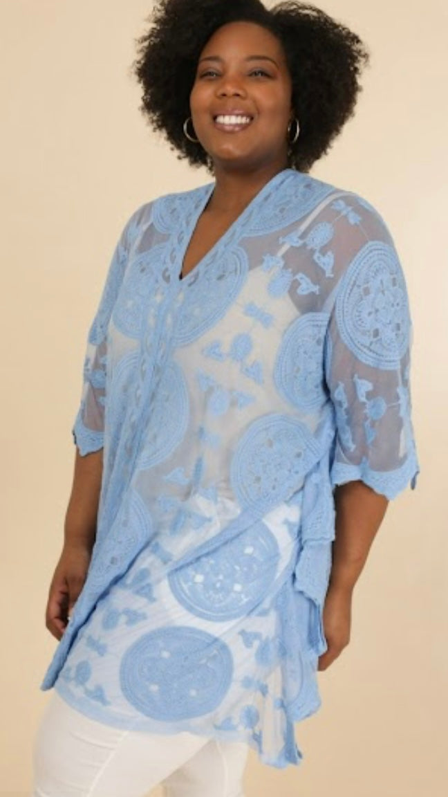 Blue lace poncho made of 65% cotton and 35% nylon.
