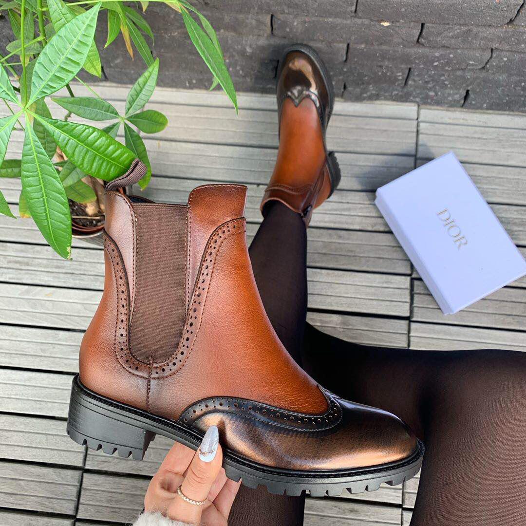 Patent brogue fleece lined boot with inner zip in a rich brown color.