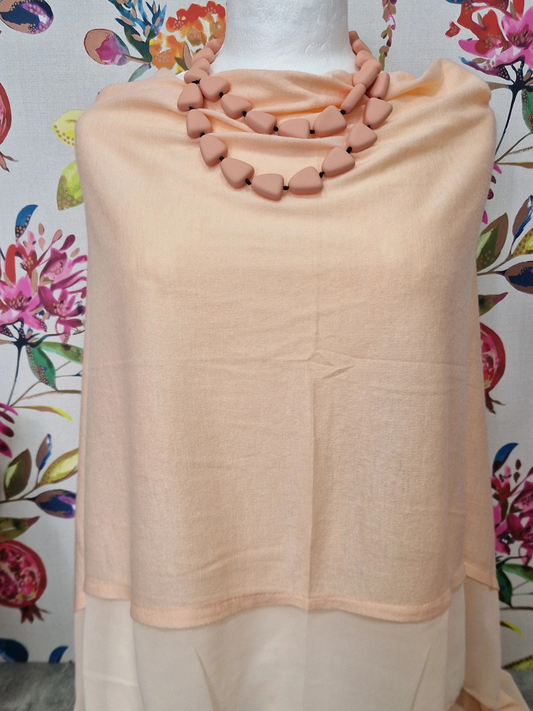 Summer Poncho and Pebbles Necklace gift bundle with floral background.