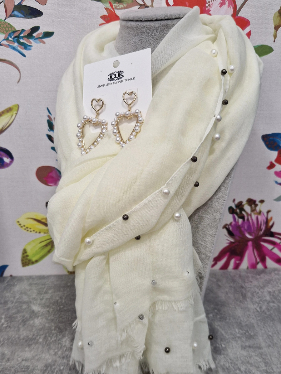 Pearl scarf and heart earrings gift bundle with floral background.