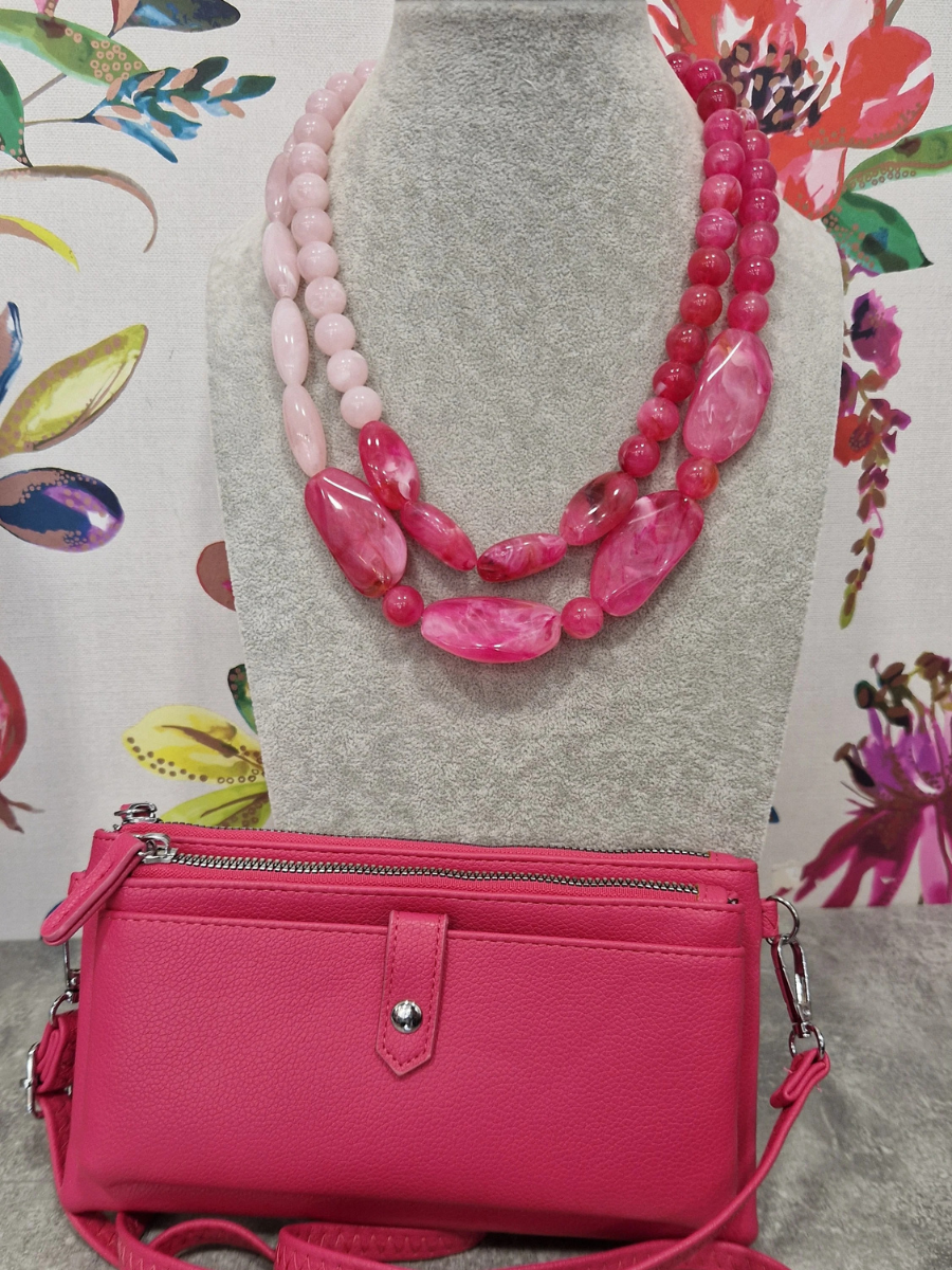 Fuchsia necklace with crossbody purse gift bundle against floral backdrop.