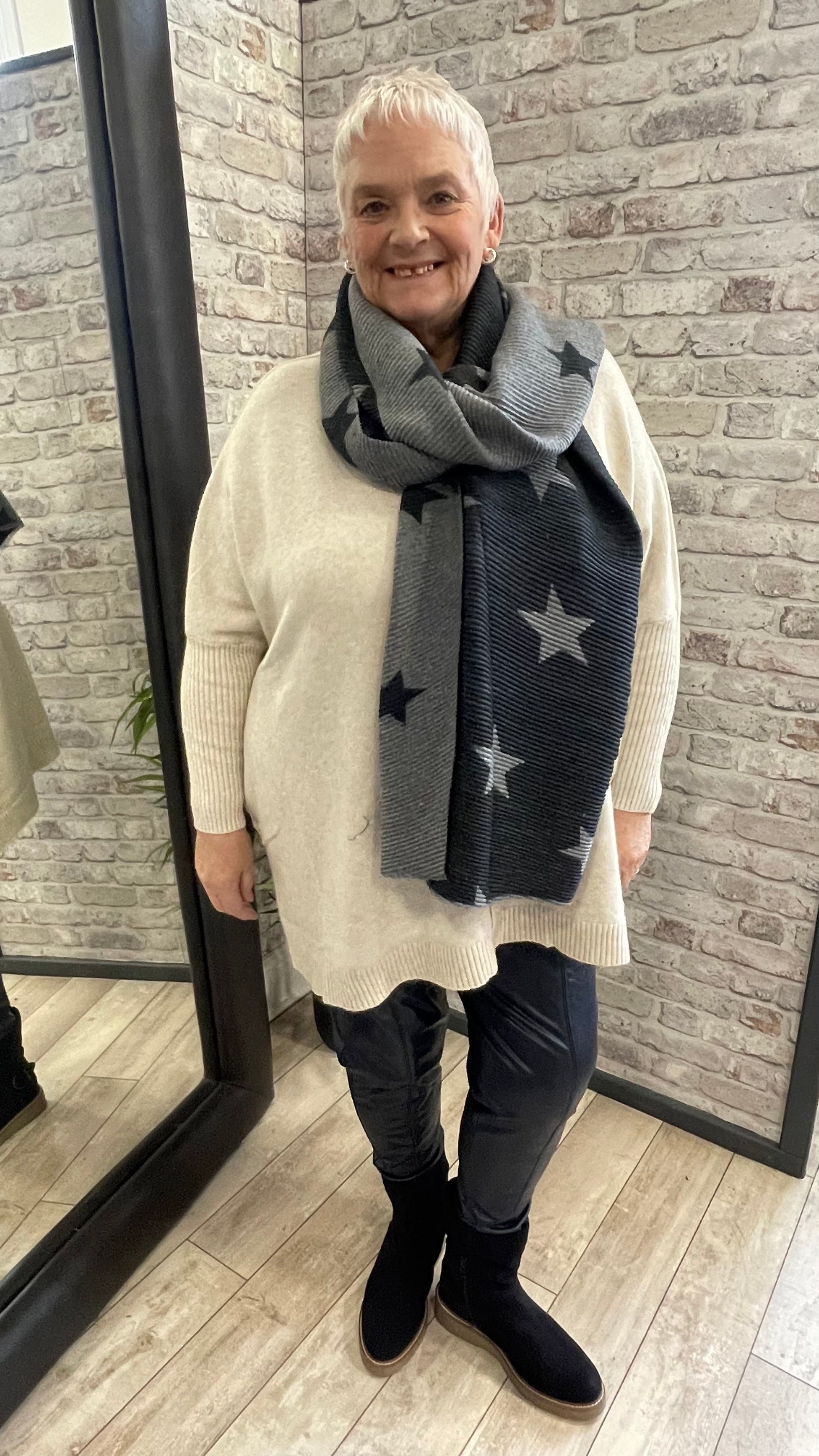 Pleated Star Scarf with textured folds and reversible colors, 100% polyester.