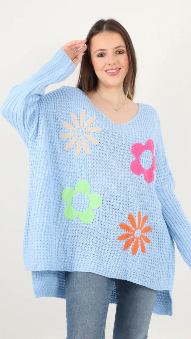 Side slit floral jumper in light blue with colorful flower designs, 100% acrylic.
