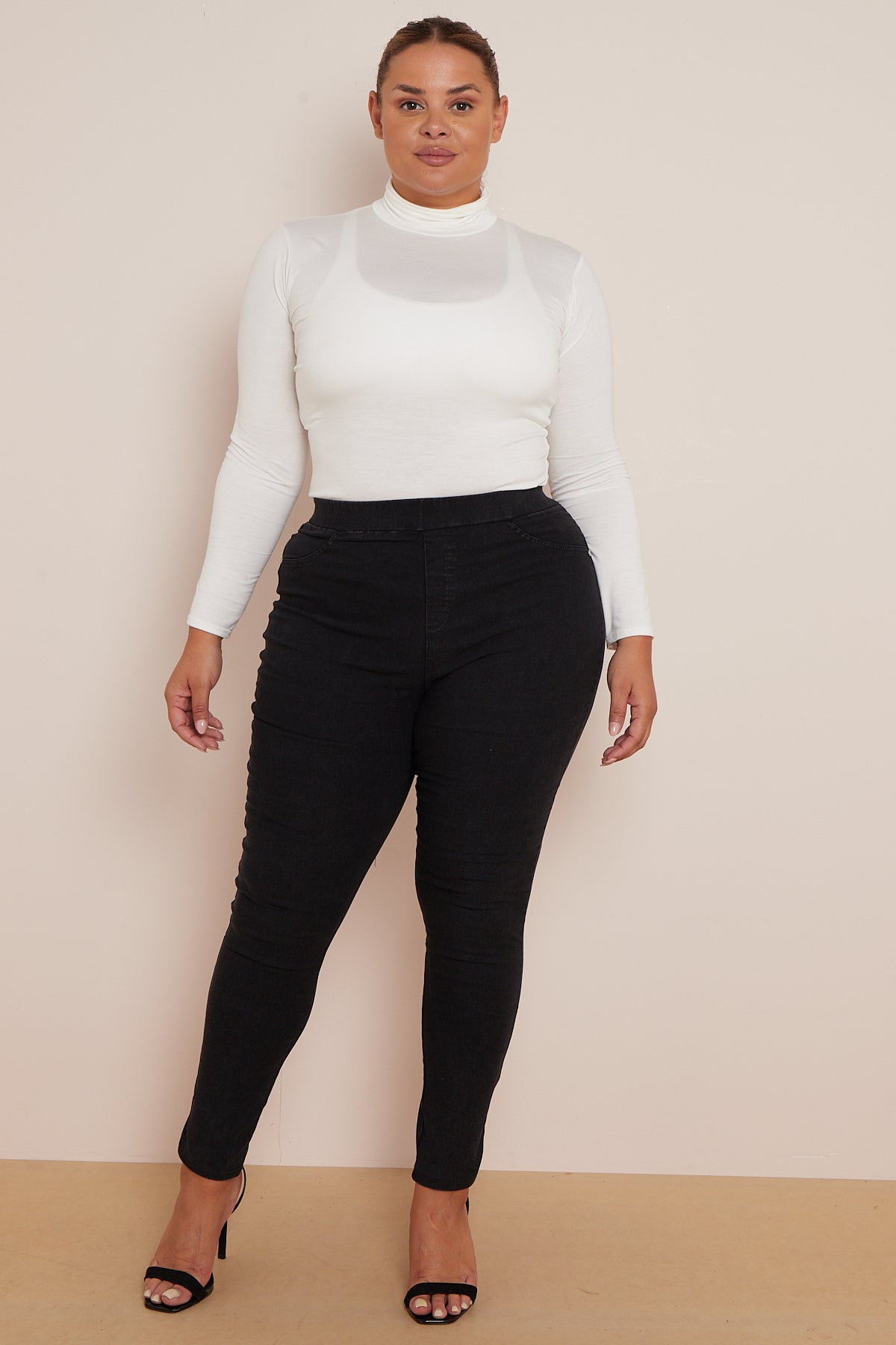 Plus-size model wearing black soft cotton jegging with white top.