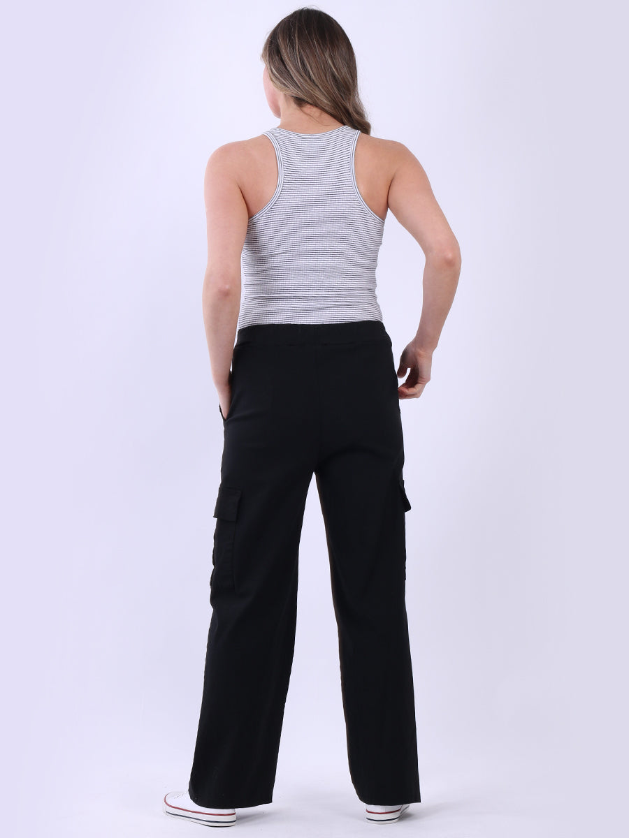 Women wearing wide leg casual magic trousers with knee flap pockets and drawstring waist.