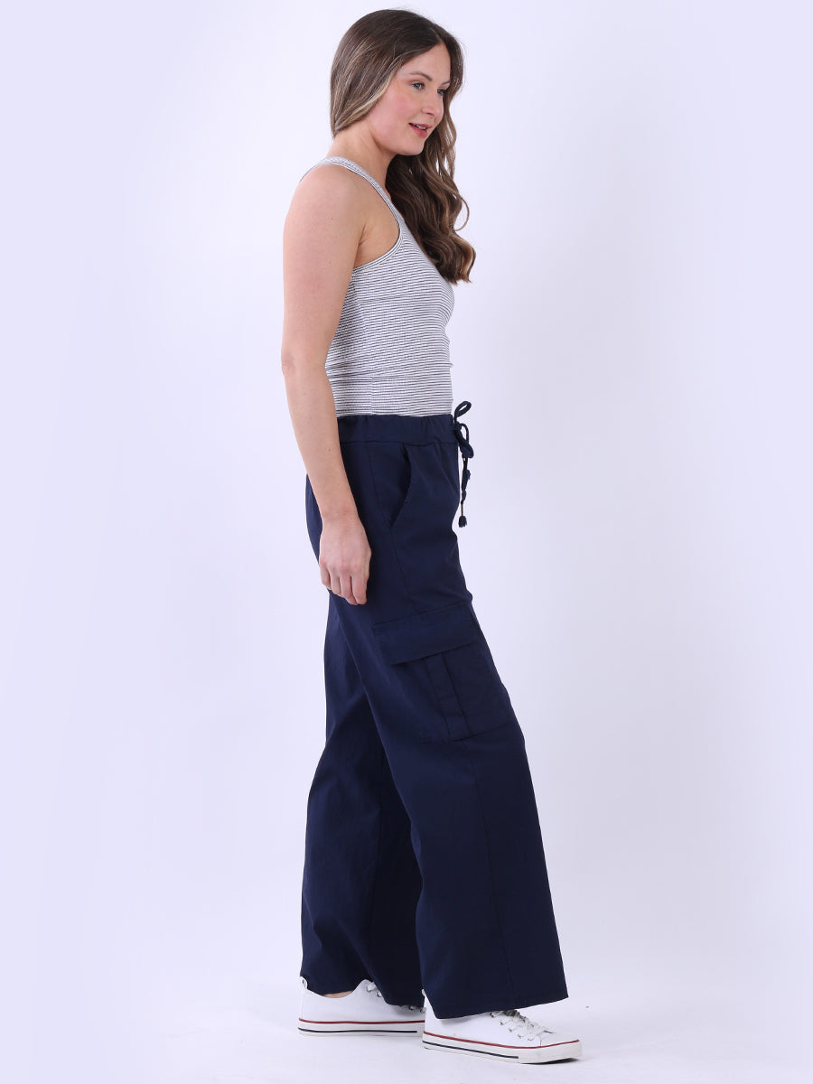 Women wearing wide leg casual magic trousers with drawstring waist and knee flap pockets.