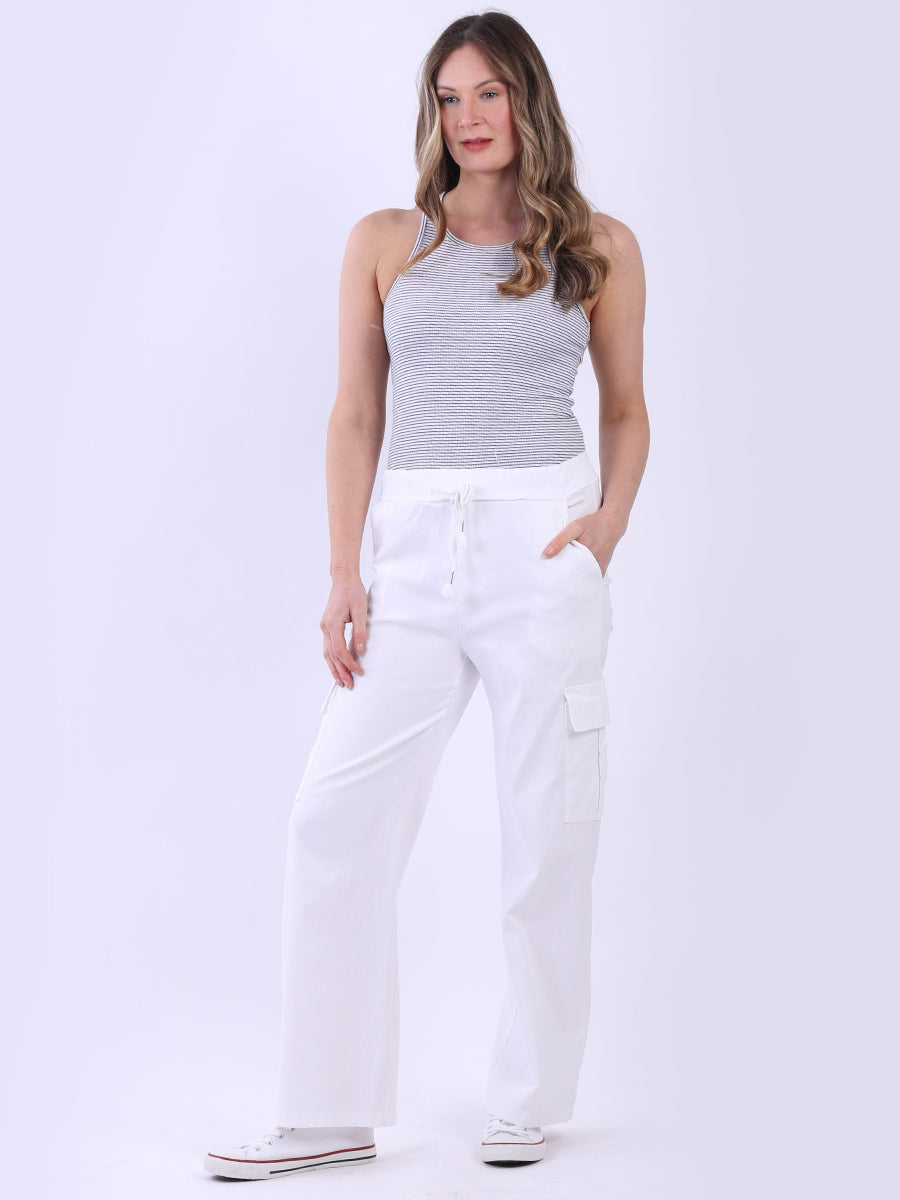 Women wearing wide leg casual magic trousers in white with drawstring waist and knee flap pockets.