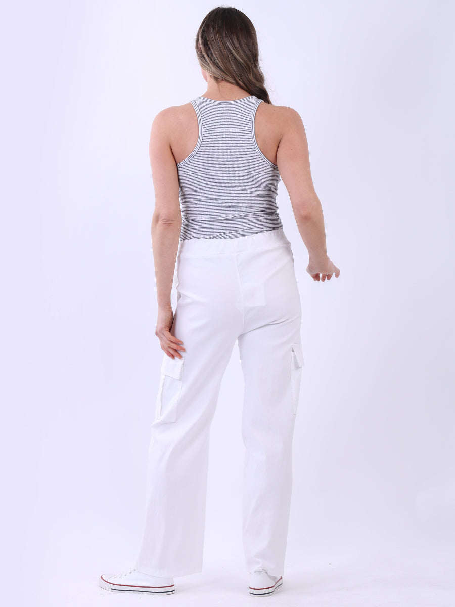 Women wearing white wide leg casual magic trousers with knee flap pockets and drawstring waist.