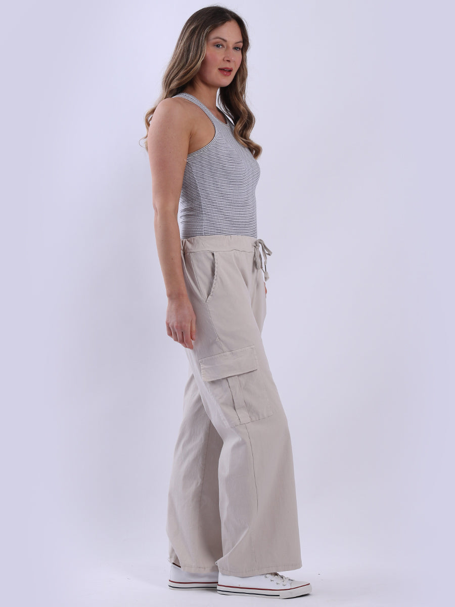 Women wearing beige wide leg casual magic trousers with drawstring waist and knee flap pockets.