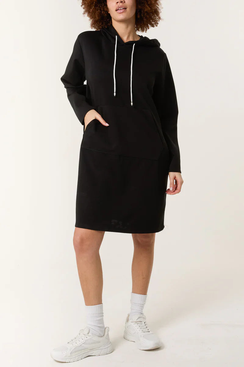 Soft Touch Hooded Sweatshirt Dress in black with drawstring hoodie and pocket, paired with sneakers.