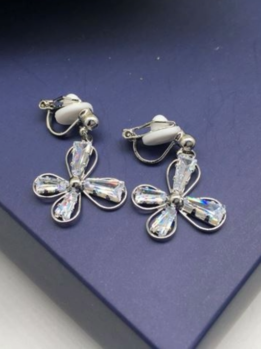 Silver clip-on flower earrings with crystal embellishments.